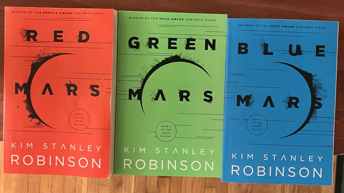Three book covers of Kim Stanley Robinson's Mars trilogy are shown side-by-side: 'Red Mars' (orange cover), 'Green Mars'…