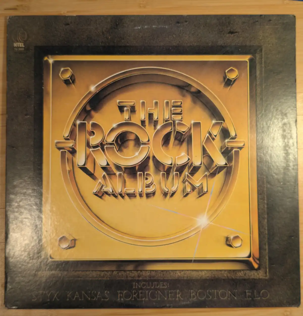 A vintage vinyl record album cover for 'The Rock Album' by KTEL, featuring a gold-plated plaque design with the title in…