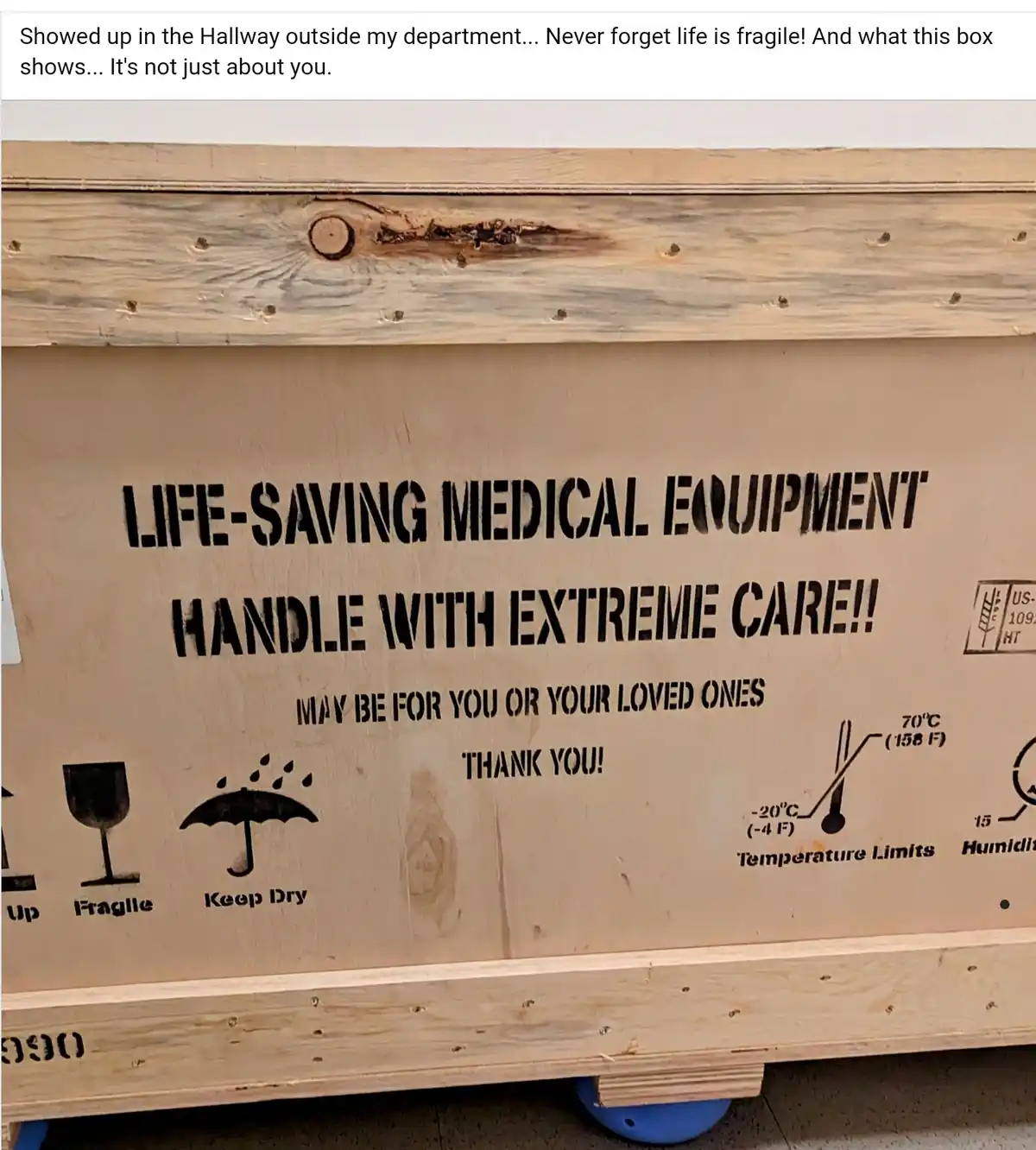 A large wooden shipping crate with stenciled black text and symbols, including 'LIFE-SAVING MEDICAL EQUIPMENT', 'HANDLE WITH…