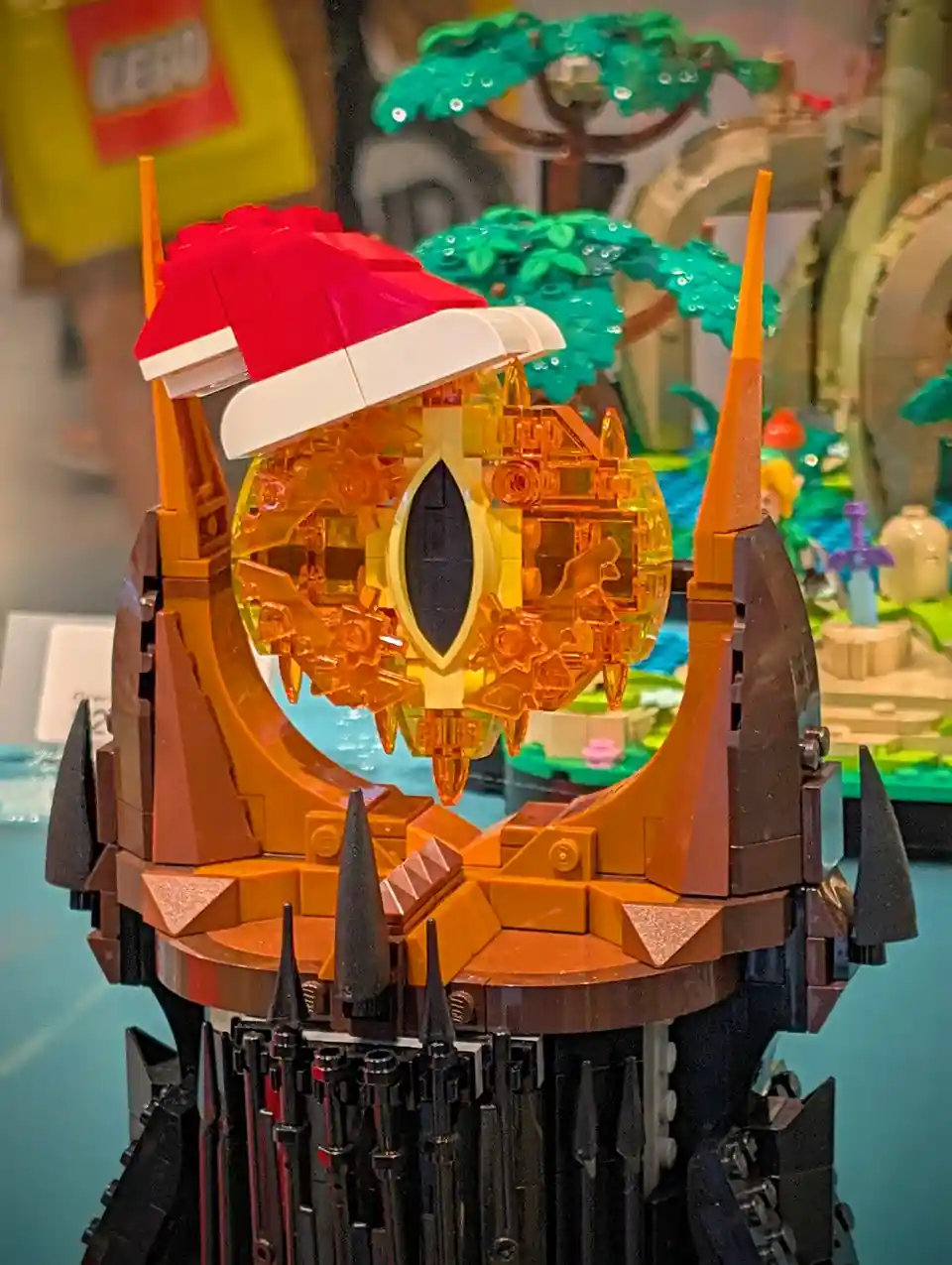 A close-up of a LEGO model of the Eye of Sauron from The Lord of the Rings, which has been humorously modified to wear a red…