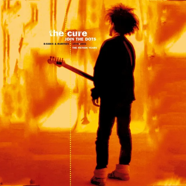 A person viewed from behind, holding a guitar, stands in front of a fiery orange background. The overlaid text reads 'the…