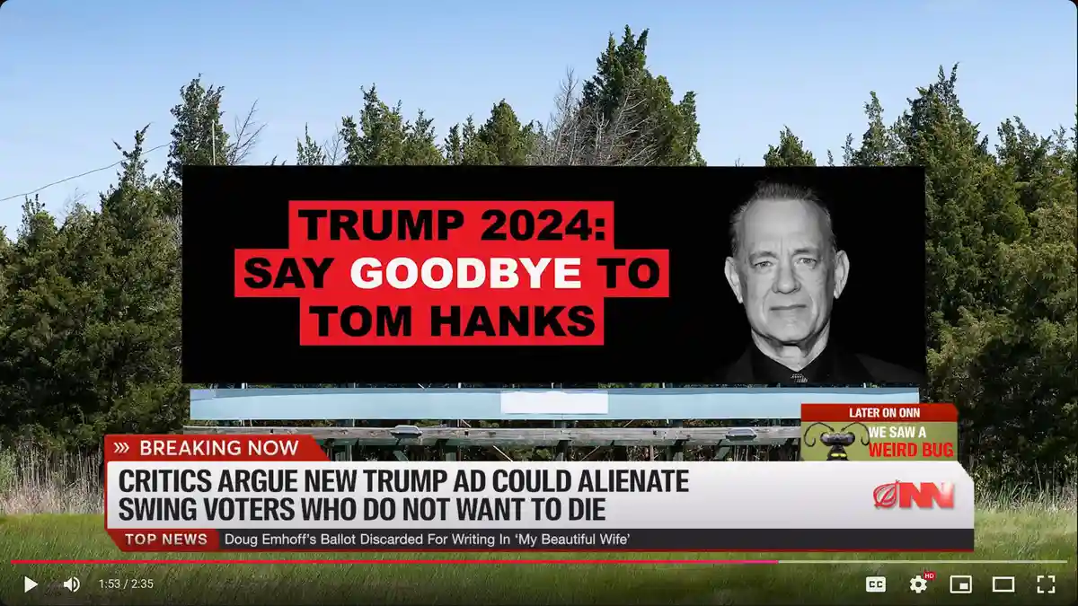 A large outdoor billboard displays a black-and-white photo of Tom Hanks alongside bold red and black text reading 'TRUMP…