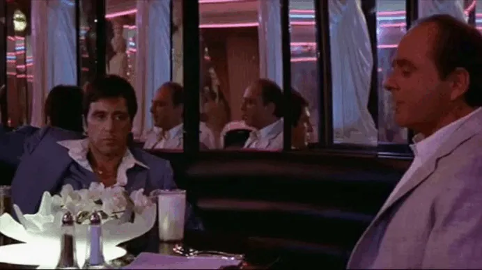 The image is a six-panel meme from the movie 'The Godfather' showing a scene where two men are seated at a restaurant table…