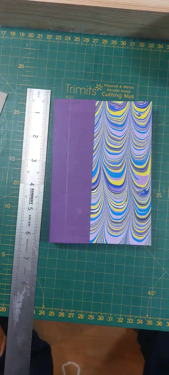 A rectangular canvas with a solid purple left half and a vibrant, swirling marbled pattern of purple, blue, and yellow on…