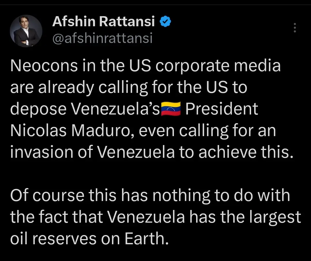 A screenshot of a tweet by Afshin Rattansi showing white text on a black background. The tweet accuses US corporate media…