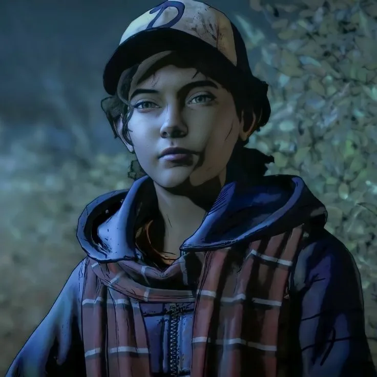 A young person with dark hair and blue eyes wears a dirty baseball cap with a 'D' logo and a plaid hooded jacket. They have…