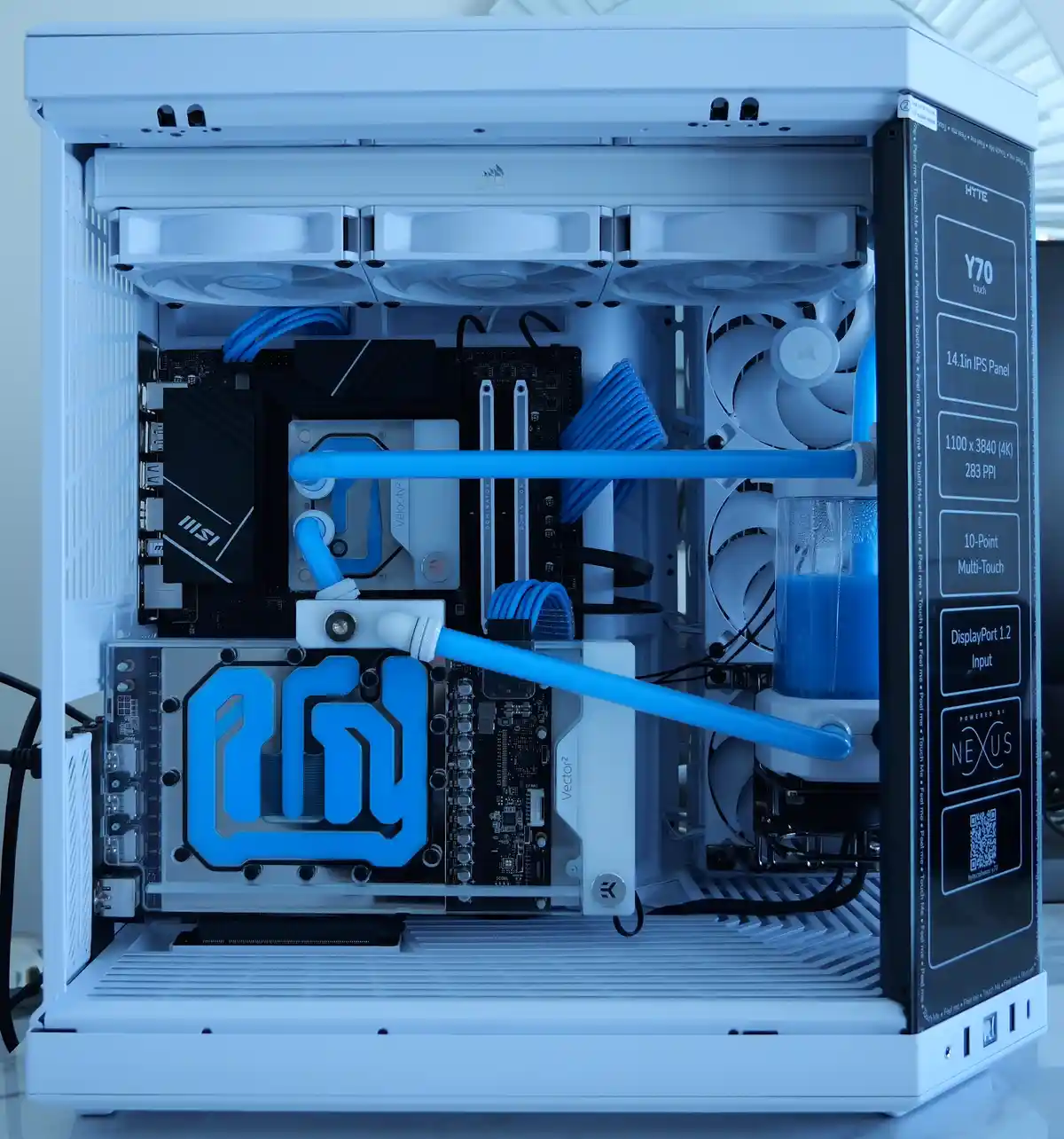 A white computer case with a liquid cooling system featuring blue tubes and fans, overlaid with text that lists…