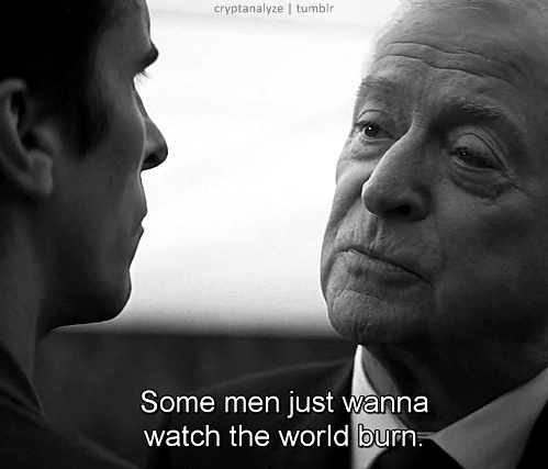 A black-and-white still shows two men in suits facing each other in a tense, dramatic moment. The older man on the right has…