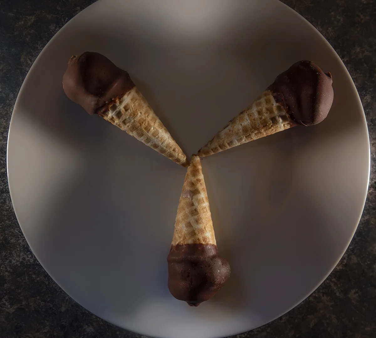 Three chocolate-dipped wafer ice cream cones are arranged on a white plate to form a 'Y' shape, with the text overlaid…