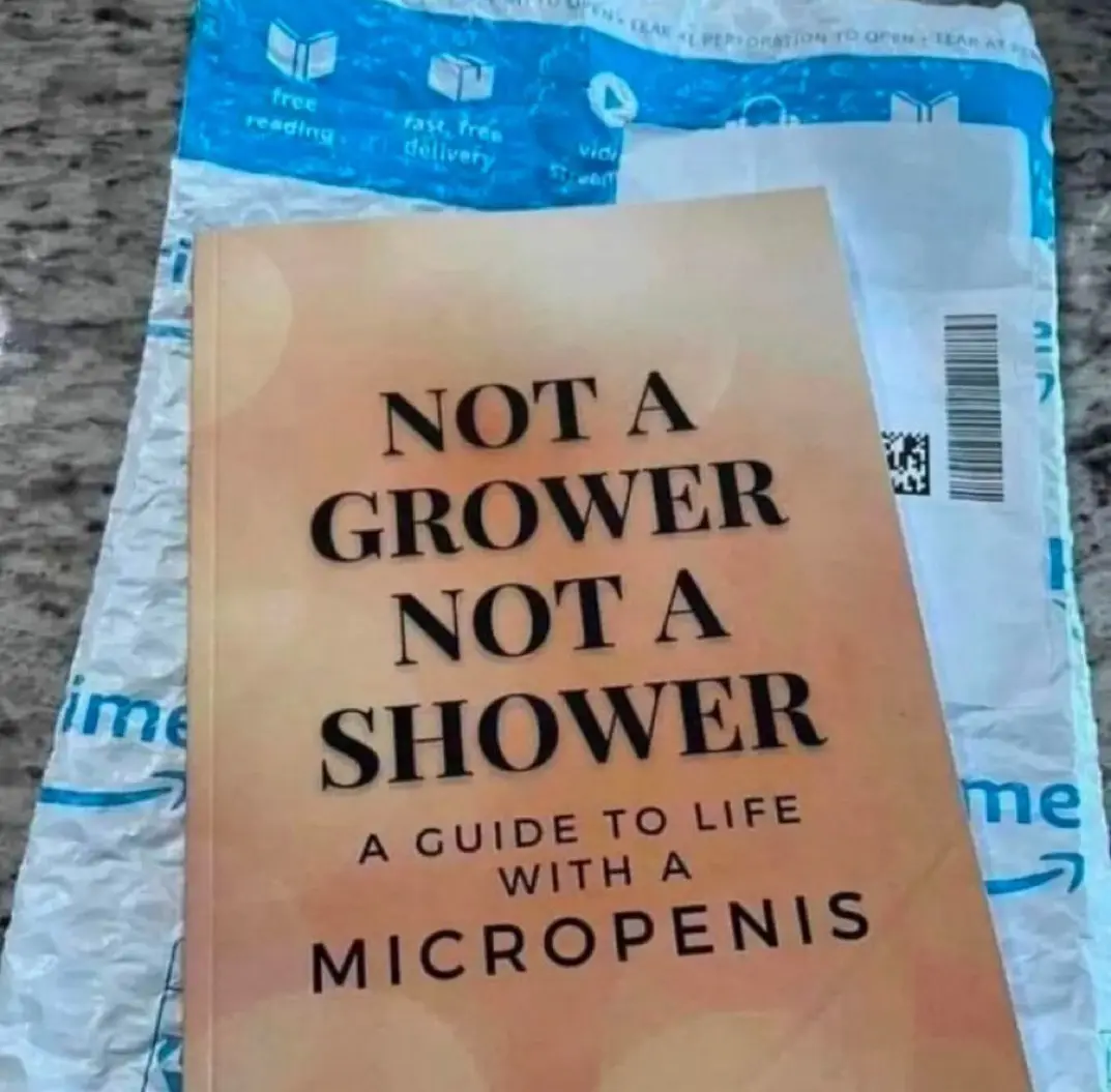 A book titled 'NOT A GROWER NOT A SHOWER A GUIDE TO LIFE WITH A MICROPENIS' rests on top of an Amazon shipping envelope. The…
