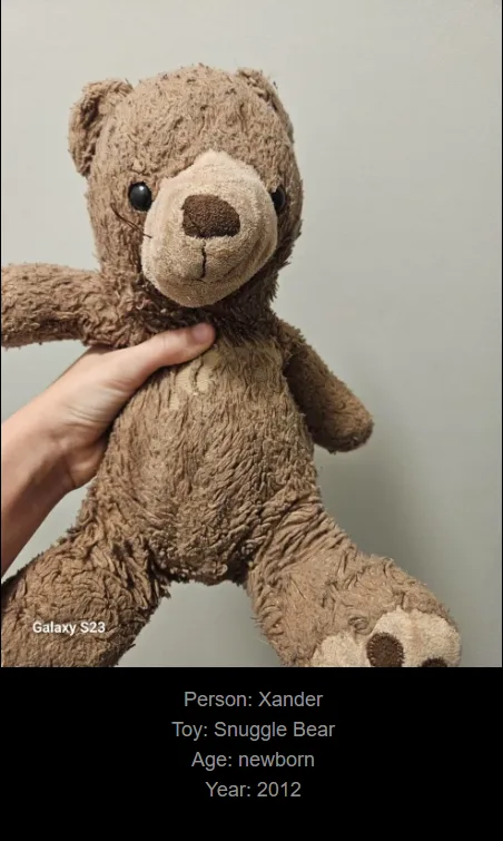 A hand holds a very worn, frayed brown teddy bear against a plain wall. Text overlaid at the bottom identifies the toy as…