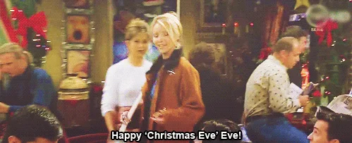 A split-screen image from the TV show 'Friends' shows Phoebe and Rachel in a festive, decorated coffee shop. In both panels…