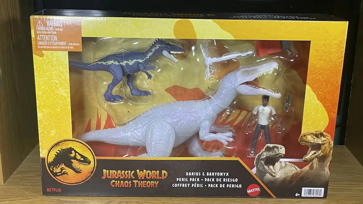 A toy box for 'Jurassic World Chaos Theory' featuring a large white Baryonyx and a smaller blue Darius dinosaur toy, along…