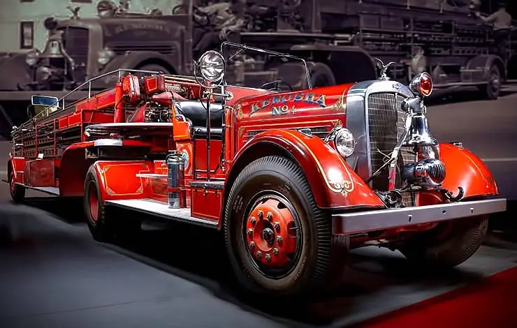 A vintage red fire truck with chrome accents and the text 'Kewauna No. 4' painted on its side is prominently displayed in…