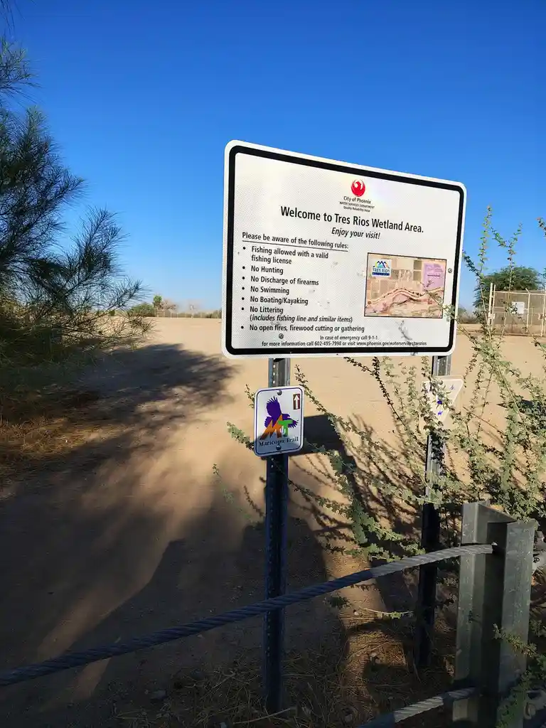 A photo of a welcome sign for the Tres Rios Wetland Area in Phoenix, Arizona, listing rules like 'No Hunting,' 'No…