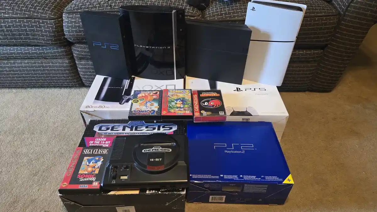 A collection of video game consoles and accessories, including a Sega Genesis, PlayStation 2, PlayStation 3, and PlayStation…