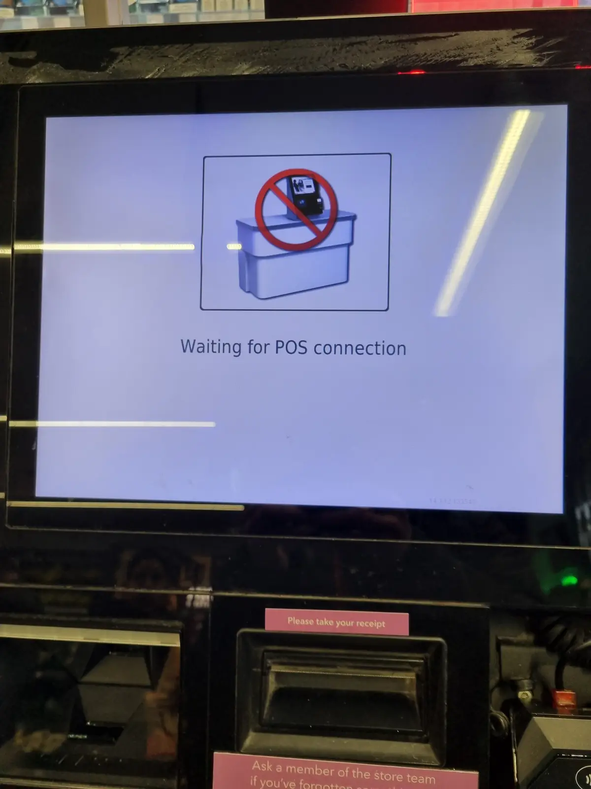 A close-up of a self-checkout terminal screen showing a graphic of a payment terminal crossed out with a red circle and…