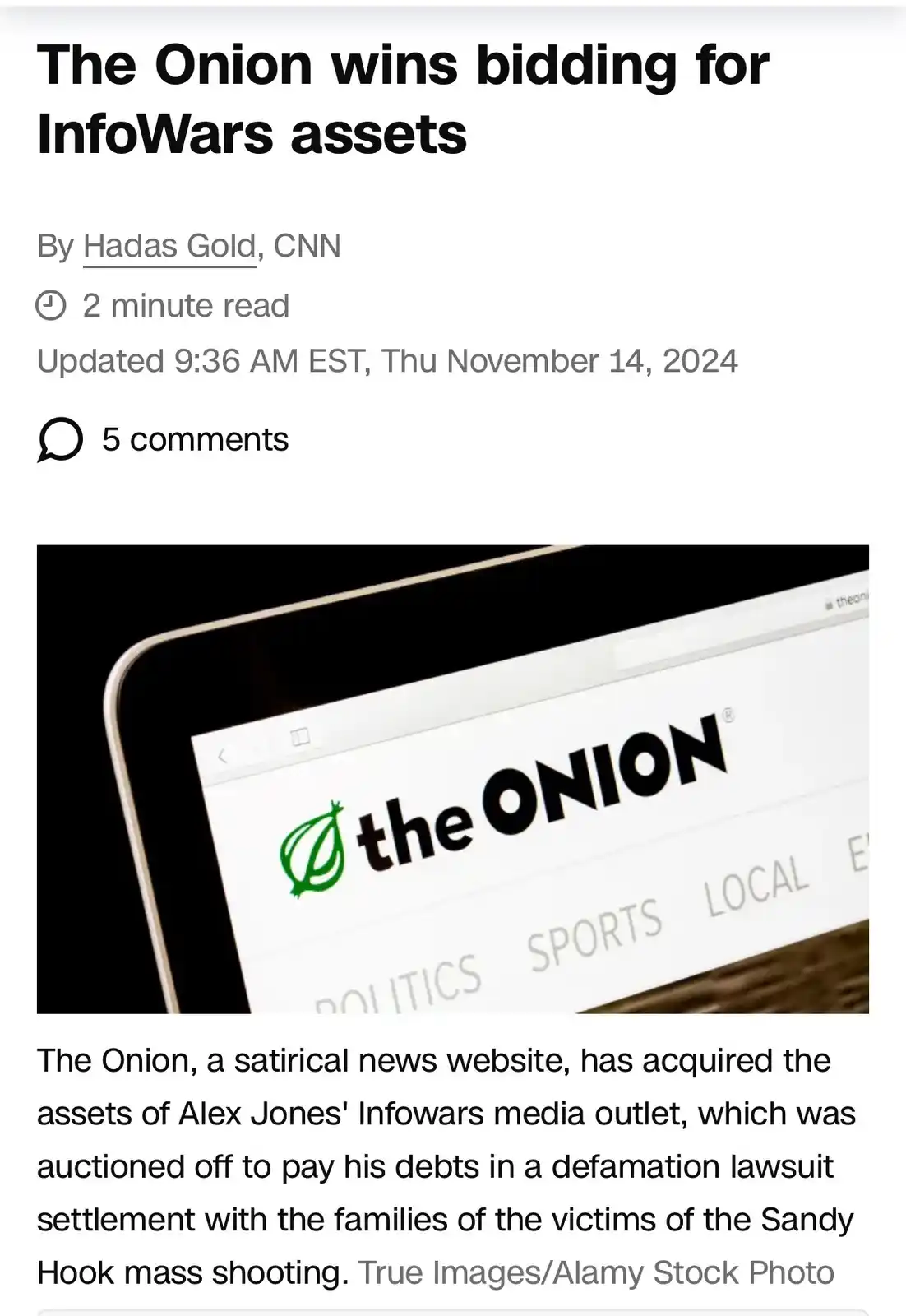 A screenshot of a fake CNN news article titled 'The Onion wins bidding for InfoWars assets' by Hadas Gold, showing a laptop…