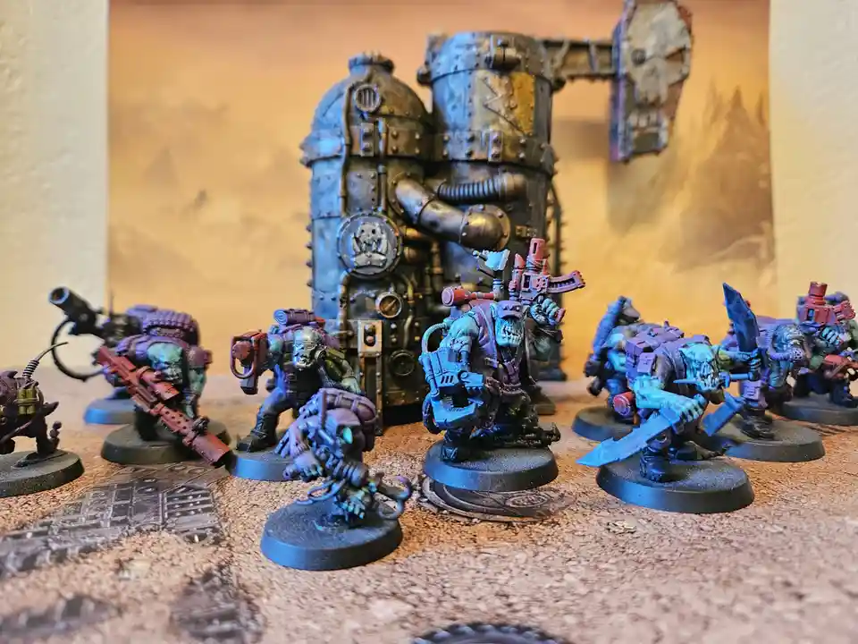 A photo of several painted miniature figures, resembling grim, green-skinned orcs or space marines, standing on a textured…