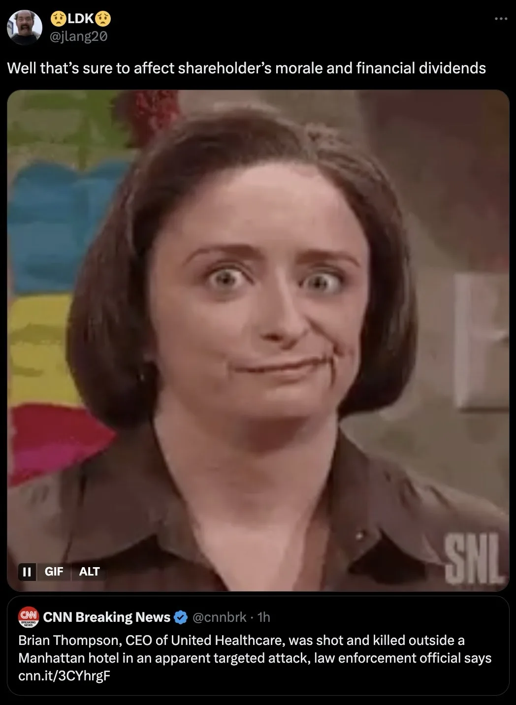 A still image from a sketch comedy show shows a woman with wide, startled eyes and a strained, forced smile, conveying a…