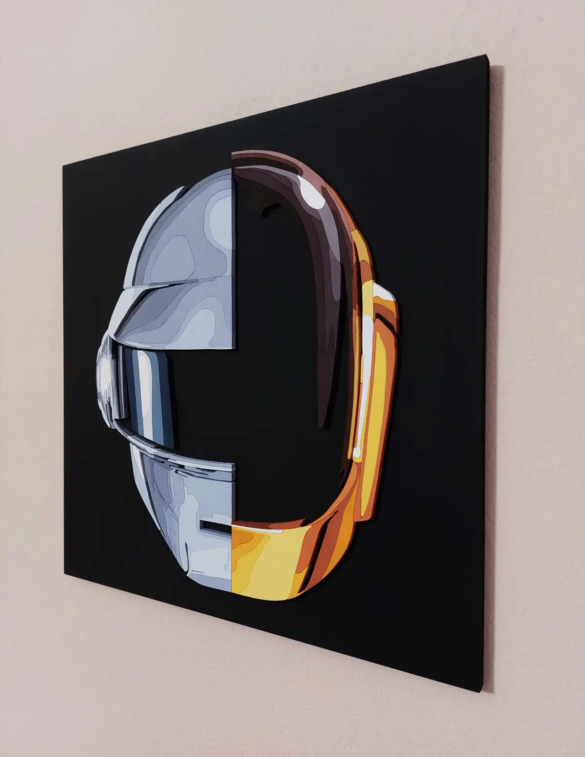 A square black canvas mounted on a wall displays a stylized, layered artwork of a helmet split vertically. The left half is…