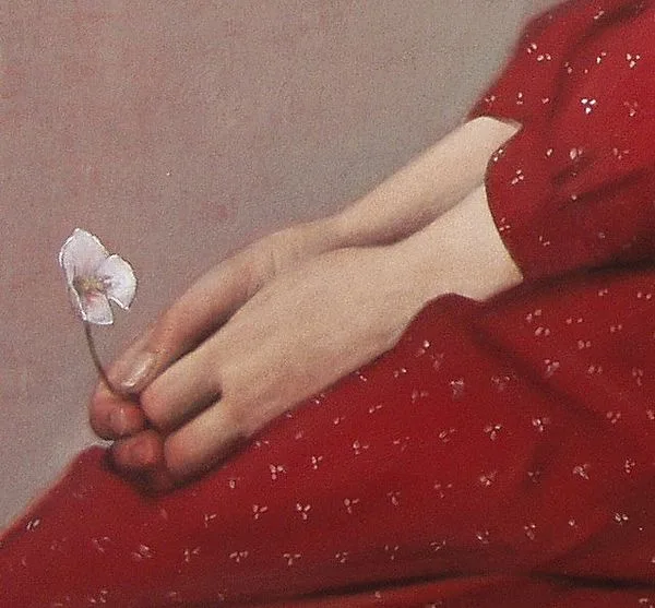 A close-up of a person's hands gently holding a small white flower against a red patterned fabric background. The overlaid…