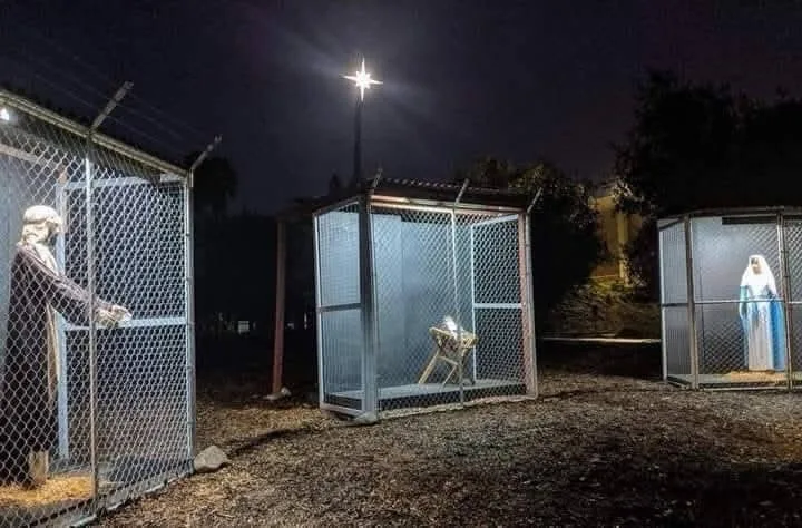 Three religious statues — Jesus, baby Jesus, and Mary — are each enclosed in separate chain-link cages at night under a…