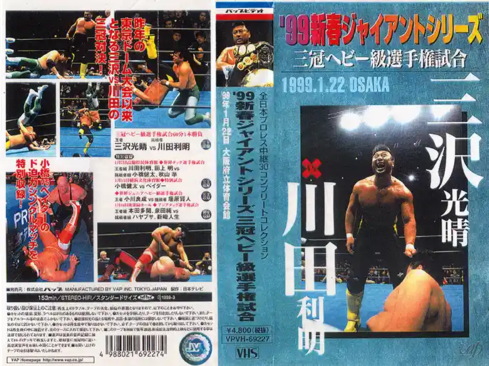 This is a VHS cover for a 1999 Japanese professional wrestling event, featuring two wrestlers, Mitsuharu Misawa and Kenta…