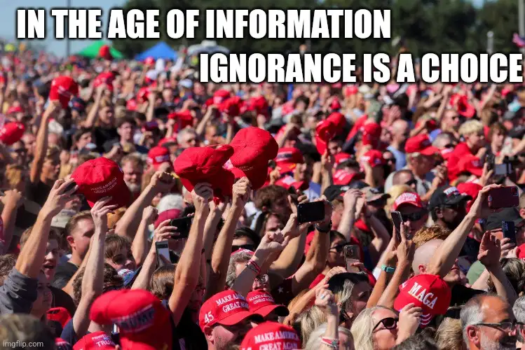 A large crowd of people, mostly wearing red 'Make America Great Again' hats, are raising their hands and holding up phones…