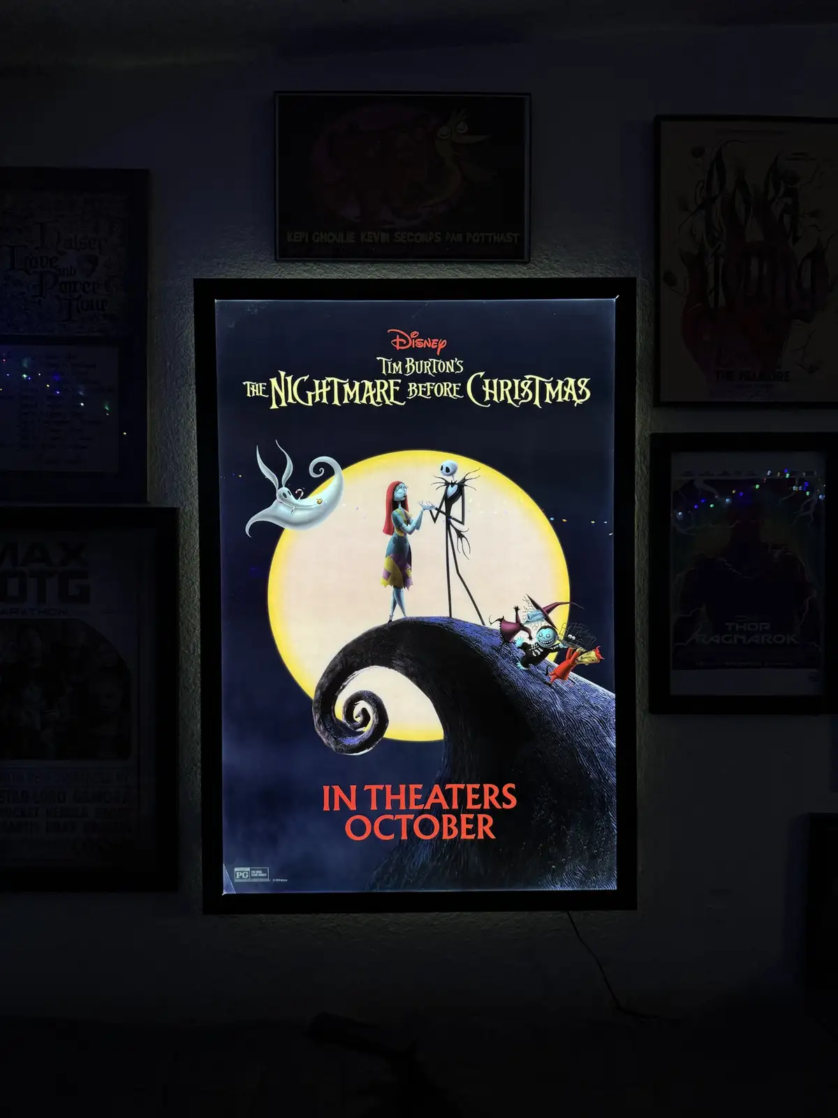 A framed poster for Disney's Tim Burton's The Nightmare Before Christmas is lit up on a wall, showing Jack Skellington and…
