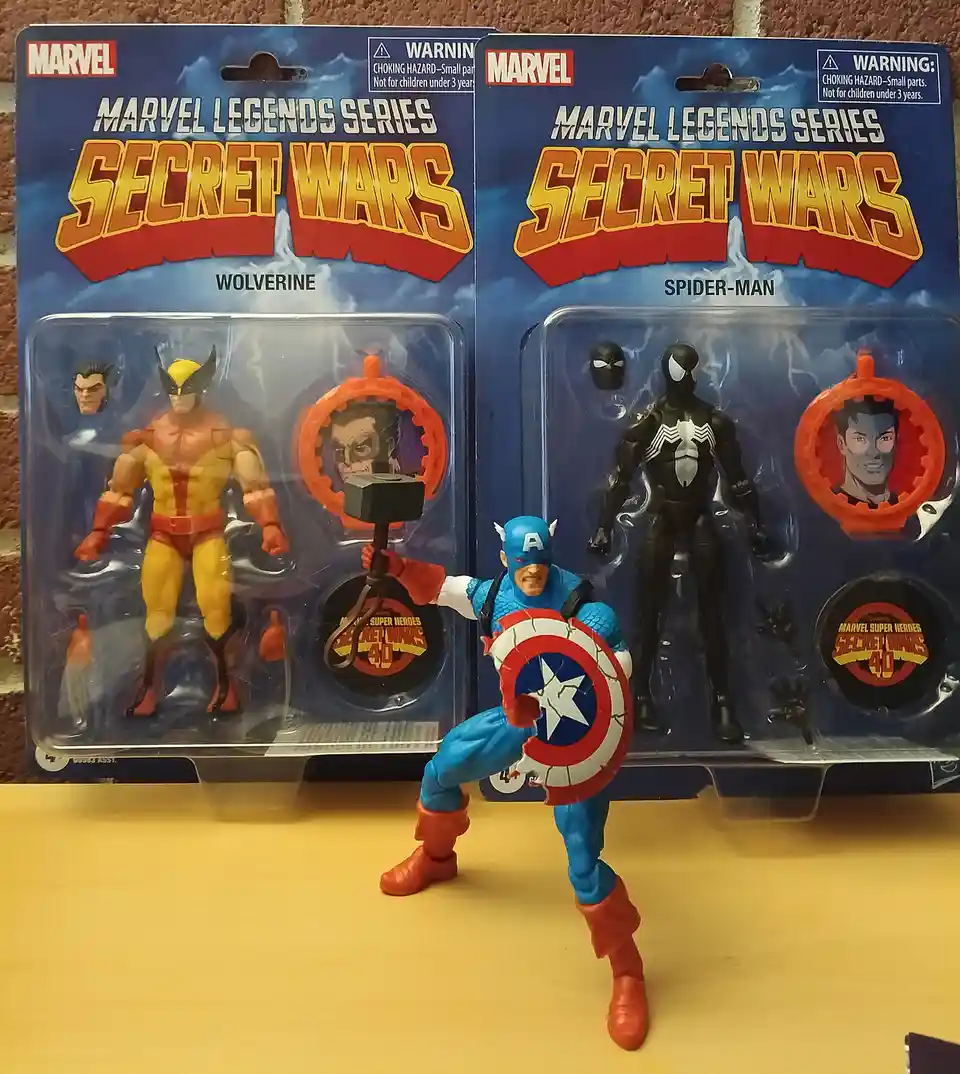Two unopened Marvel Legends Series Secret Wars action figure packs for Wolverine and Spider-Man stand side-by-side on a…