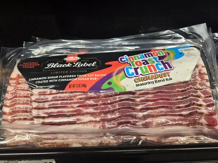 A package of Black Label bacon, labeled 'Cinnamon Toast Crunch' with 'Cinnadust seasoning blend rub', is displayed on a…
