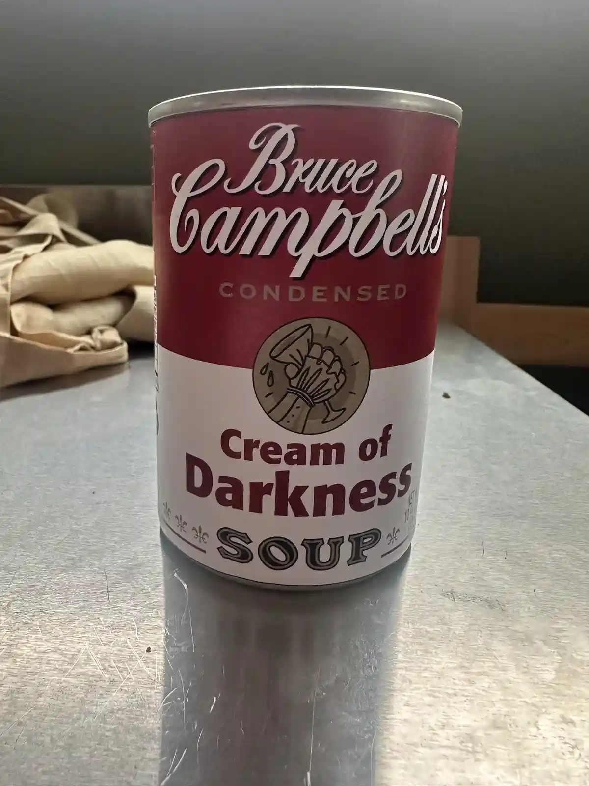 A can of soup with a red and white label, styled like Andy Warhol's Campbell's Soup cans, but with 'Bruce Campbell's…