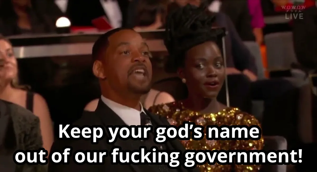 A still image of Will Smith and Jada Pinkett Smith seated in an audience, both looking upward with expressions of shock or…