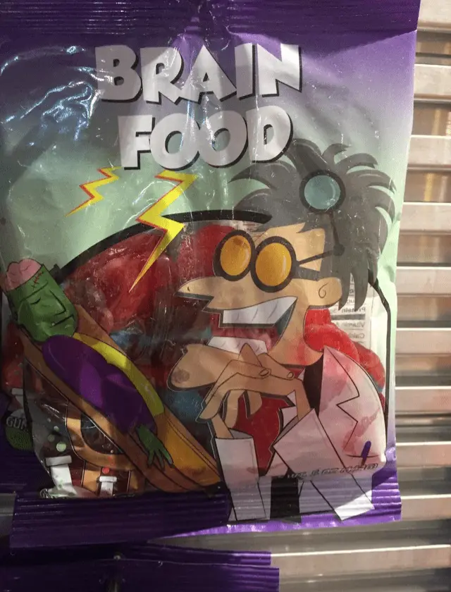 A purple snack bag labeled 'BRAIN FOOD' features a cartoon scientist with wild hair and goggles, holding a broken brain…