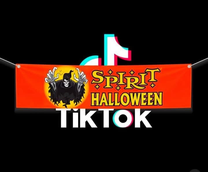 An orange banner with a cartoon grim reaper and the text 'SPIRIT HALLOWEEN' is shown hanging against a black background…
