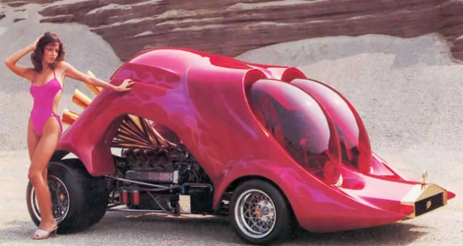 A woman in a pink swimsuit poses next to a highly stylized, futuristic pink car with a large, bulbous, face-like front end…