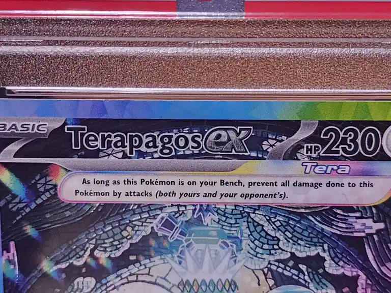 A close-up of a Pokémon TCG card for Terapagos EX, showing its HP 230 and a text box that reads 'As long as this Pokémon is…