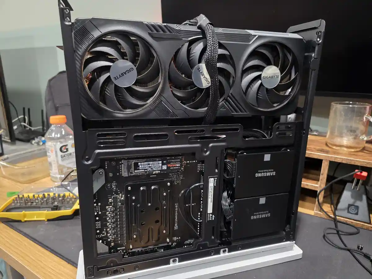 A computer case is shown open, revealing its internal components including a Gigabyte graphics card with three fans, Samsung…