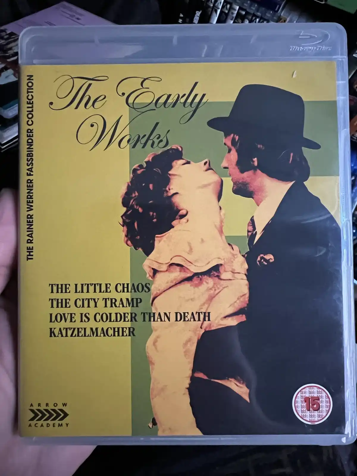 A hand holds a Blu-ray case for 'The Early Works' from 'The Rainer Werner Fassbinder Collection,' featuring a stylized image…