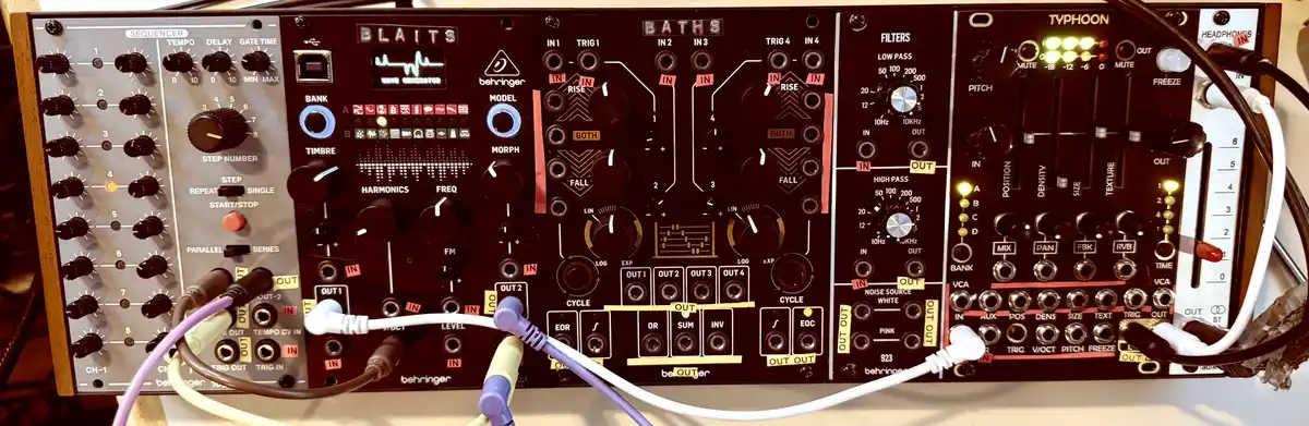 A close-up photo of a Behringer modular synthesizer with multiple modules like 'BLAITS', 'BATHS', and 'TYPHOON' connected by…