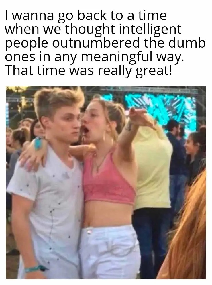 A young woman in a pink crop top and white shorts is yelling or singing loudly while embracing a young man in a white…