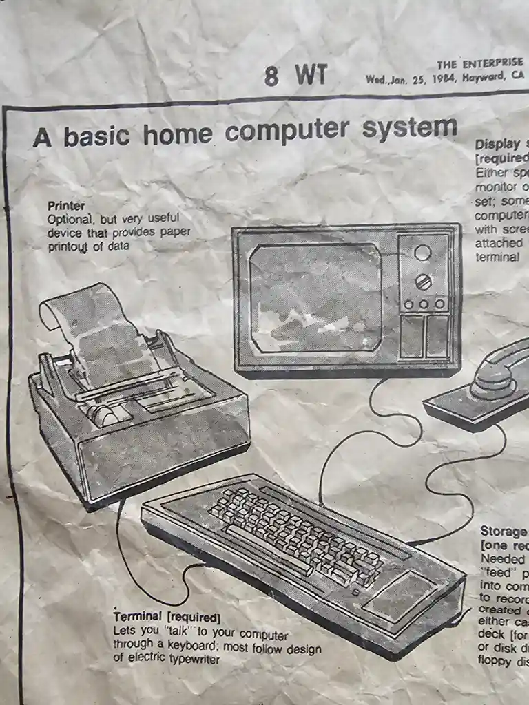 A 1984 newspaper clipping from 'The Enterprise' shows a diagram of a basic home computer system with a keyboard, monitor…