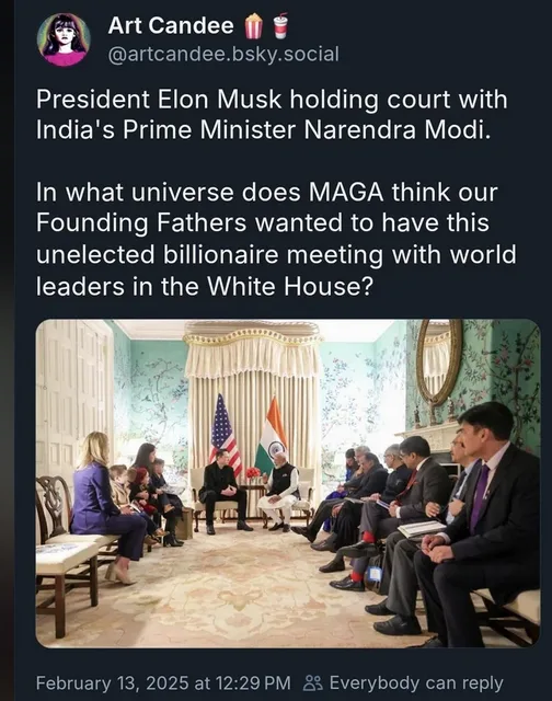 An image shows a formal meeting in a room with American and Indian flags, where a man in a dark suit sits facing a group of…