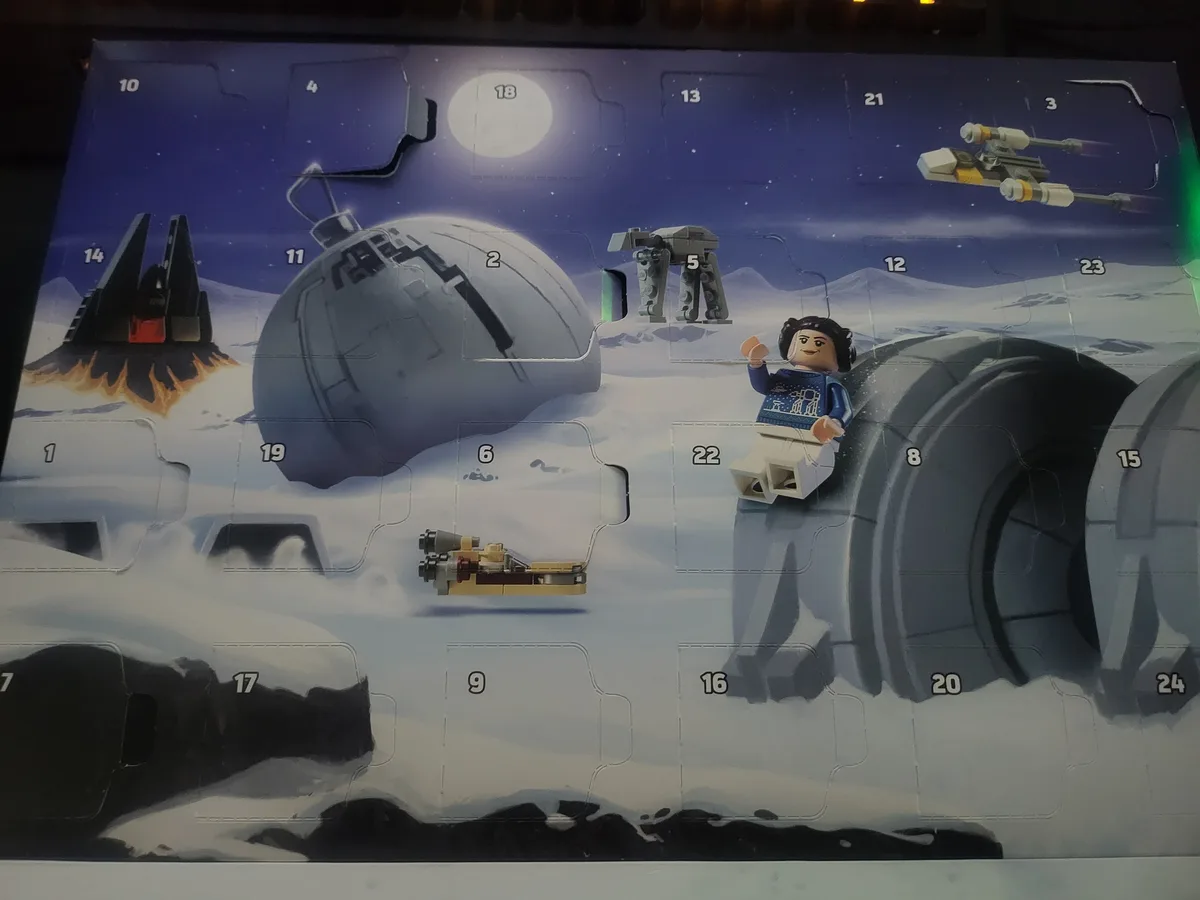 A Lego Star Wars Advent calendar with 24 numbered flaps, depicting a snowy Hoth landscape with iconic Star Wars elements…