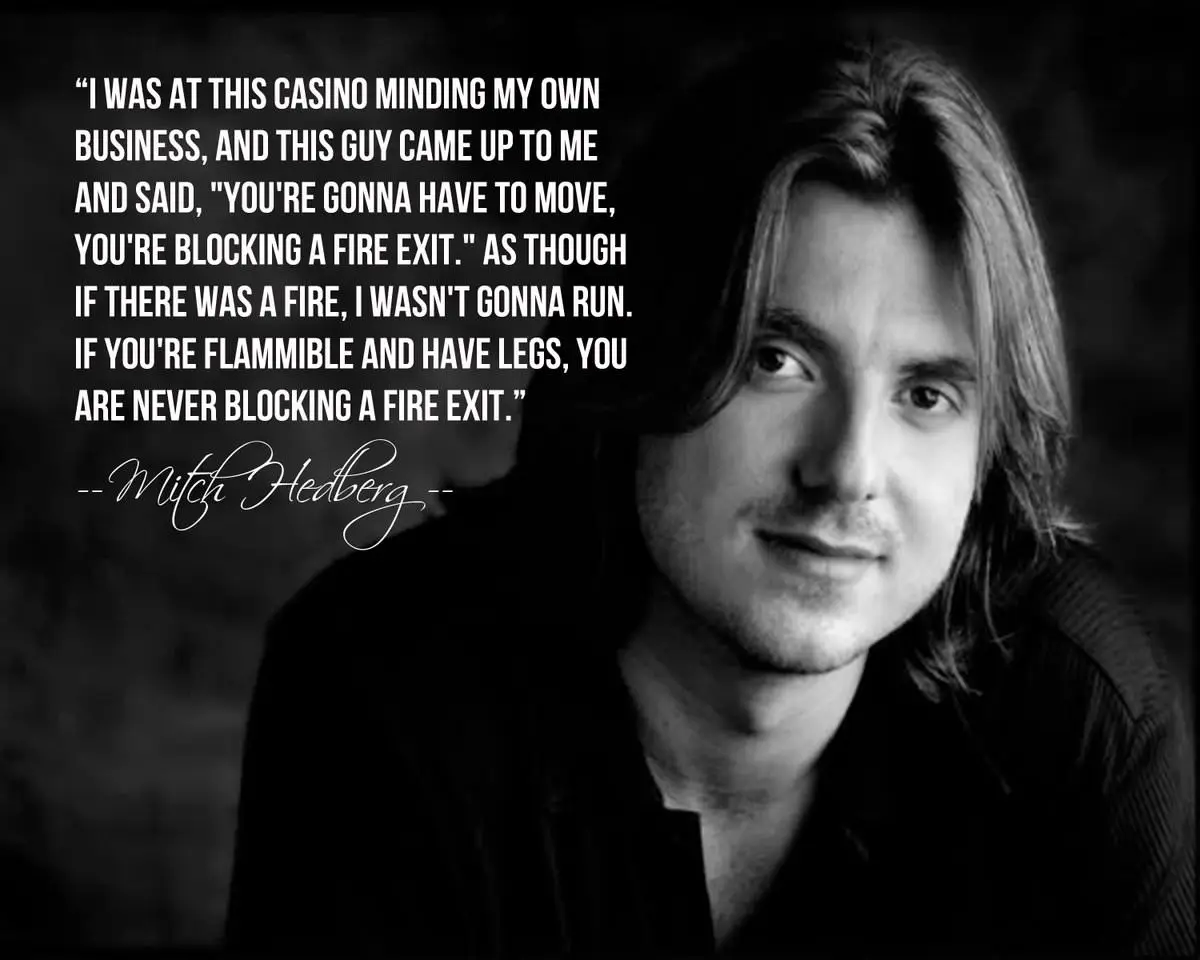 A black and white portrait of comedian Mitch Hedberg, with a large block of white text overlaid on the left side. The text…