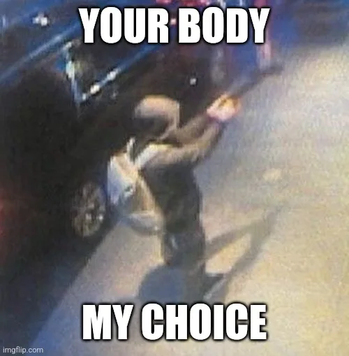 A low-resolution, grainy security camera image shows a person in a hoodie and backpack holding a long object, possibly a…