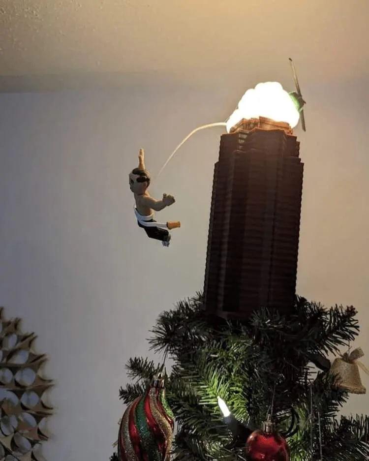 A small, plastic action figure of a man in a white belt and black pants is suspended mid-air, appearing to be flying or…