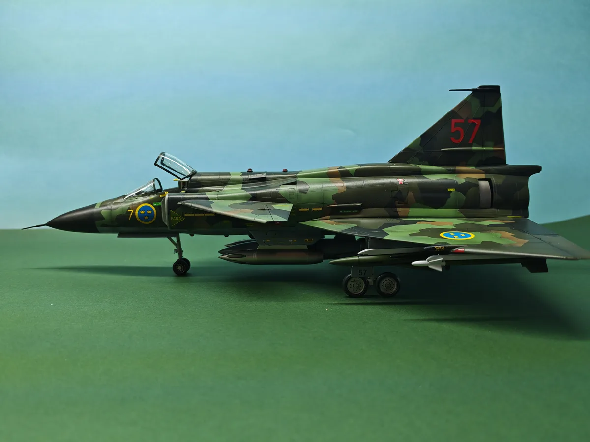 A detailed scale model of a Swedish Saab 37 Viggen fighter jet, painted in green and brown camouflage with red '57' on the…