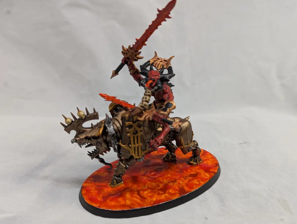 A highly detailed, hand-painted miniature of a demonic rider on a spiked, armored beast, wielding a large, jagged sword. The…